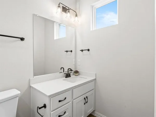 a bathroom with a sink a toilet and a mirror