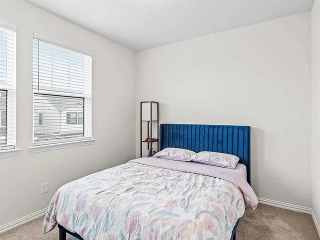 a bed sitting in a bedroom next to a window