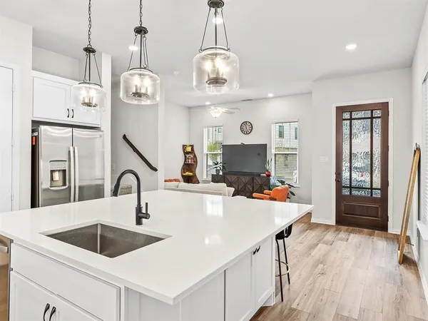 a kitchen with a refrigerator a sink and chandelier