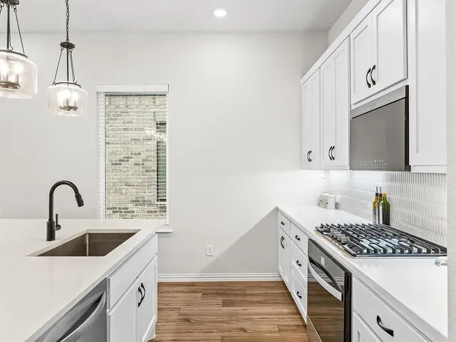 a kitchen with a sink and a stove top oven