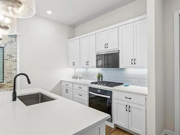 a kitchen with white cabinets appliances and sink