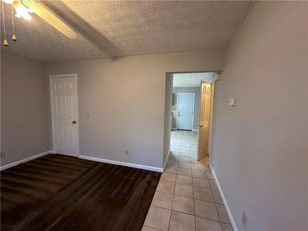 a view of a hallway with wooden floor and a bathroom