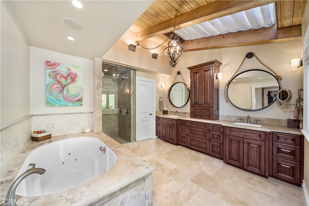 822 Emerald Bay Laguna Beach, CA 92651 - Photo 16 of 26 a large bathroom with a tub double vanity sink and a mirror