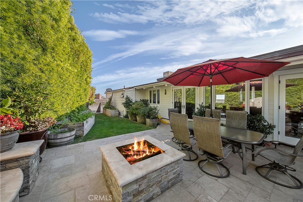 822 Emerald Bay Laguna Beach, CA 92651 - Photo 21 of 26 a patio with a table and chairs under an umbrella