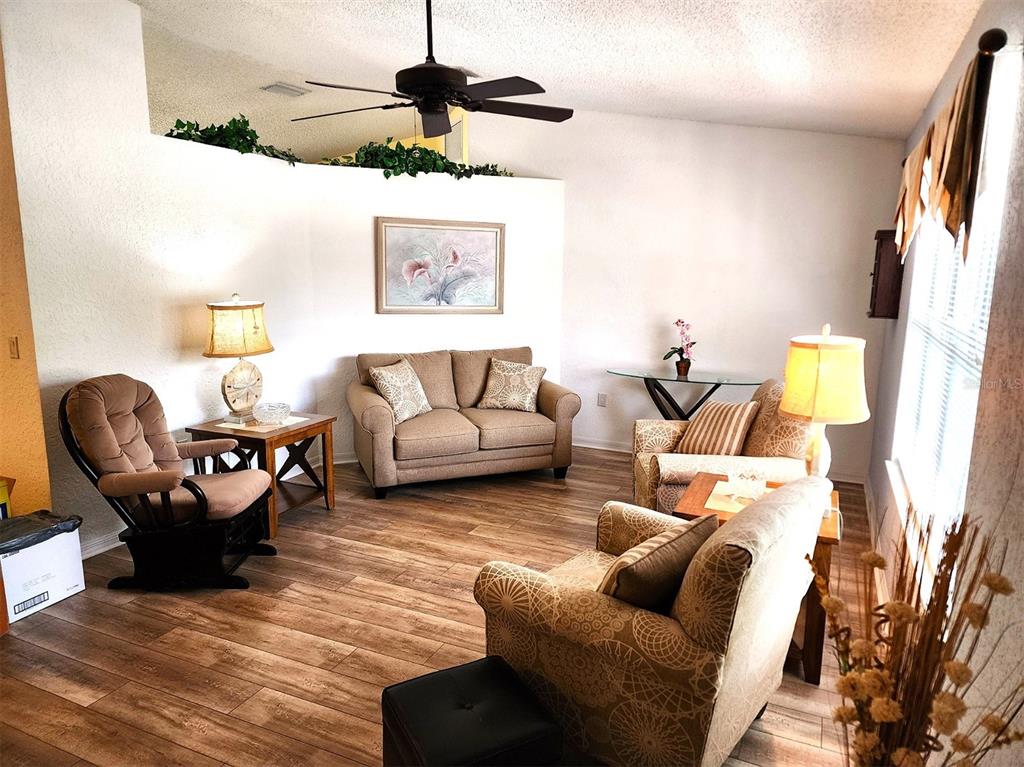 11660 Southwest 89th Terrace Ocala, FL 34481 - Photo 4 of 16 a living room with furniture and a wooden floor