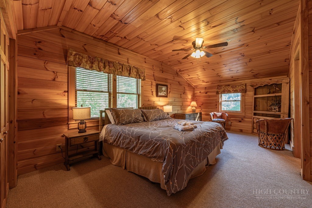 197 Woodby Ridge Road Vilas, NC 28692 - Photo 27 of 45 a spacious bedroom with a bed a table and chairs