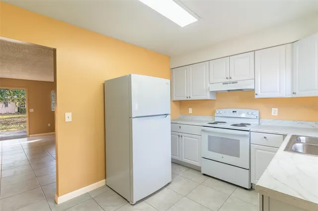 a kitchen with a refrigerator sink and cabinets