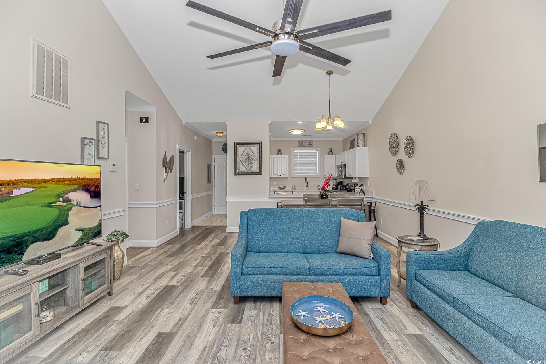 4647 Wild Iris Drive, Unit 303 Myrtle Beach, SC 29577 - Photo 14 of 29 Living room with light wood finished floors, high vaulted ceiling, and a chandelier