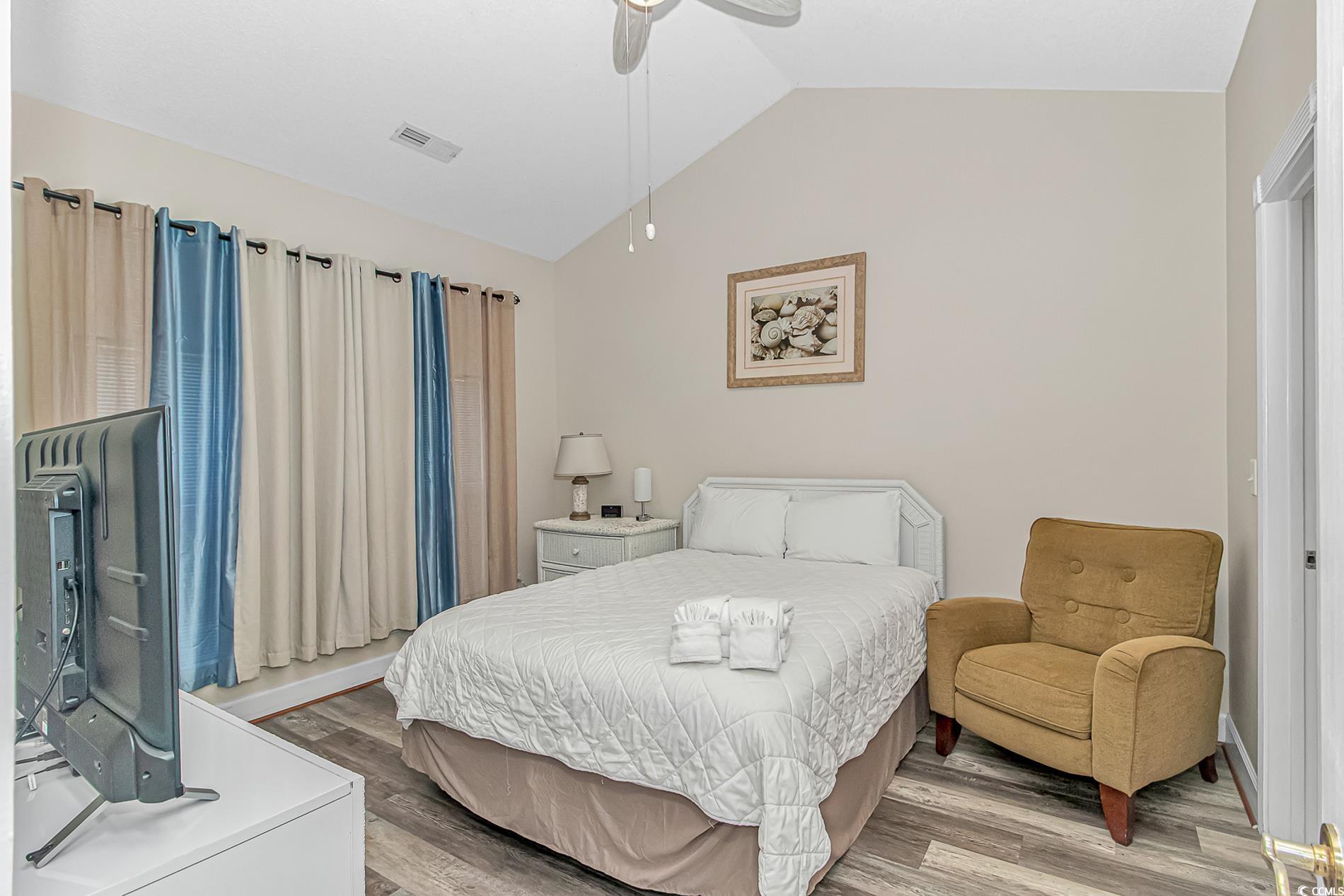 4647 Wild Iris Drive, Unit 303 Myrtle Beach, SC 29577 - Photo 16 of 29 Bedroom featuring lofted ceiling, wood finished floors, and ceiling fan