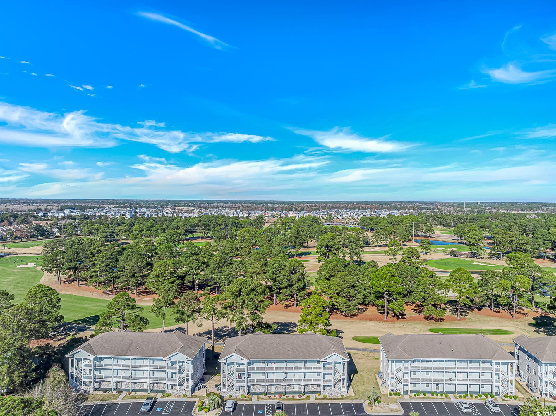4647 Wild Iris Drive, Unit 303 Myrtle Beach, SC 29577 - Photo 2 of 29 Drone / aerial view of a golf club and a tree filled landscape