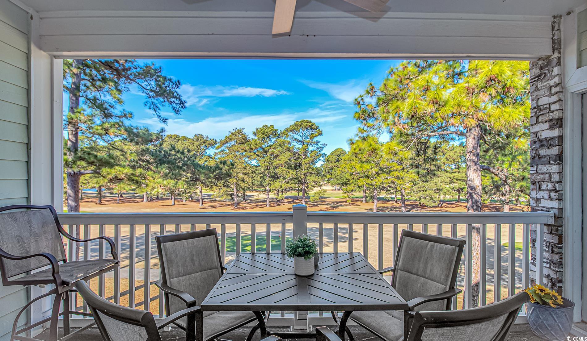 4647 Wild Iris Drive, Unit 303 Myrtle Beach, SC 29577 - Photo 22 of 29 Deck featuring a ceiling fan, outdoor dining area, and view of wooded area