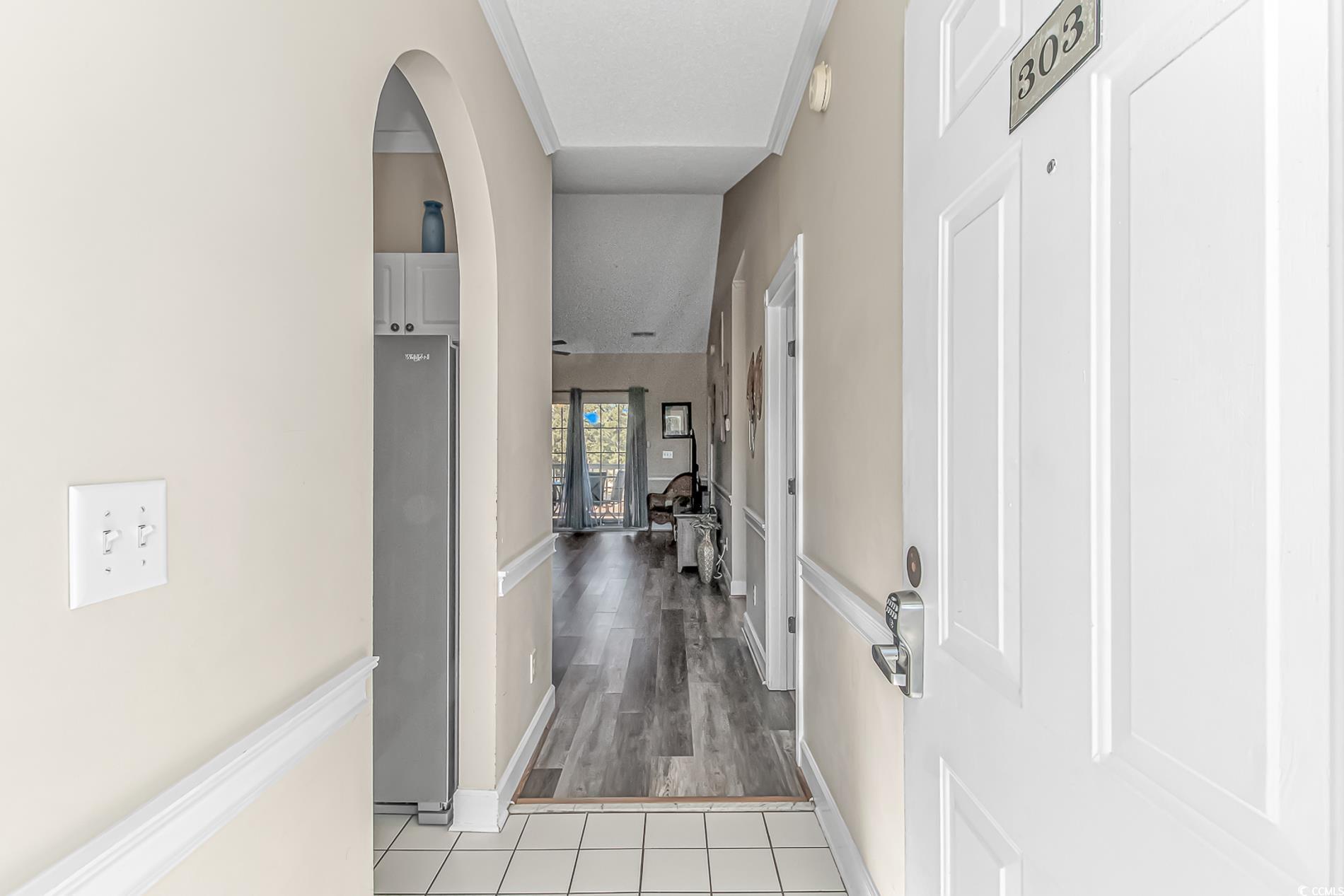 4647 Wild Iris Drive, Unit 303 Myrtle Beach, SC 29577 - Photo 6 of 29 Hallway featuring arched walkways and light tile patterned floors