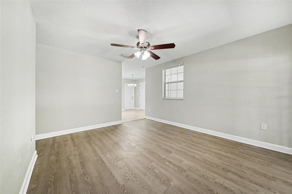 1109 Inland Street Leesburg, FL 34748 - Photo 6 of 15 an empty room with wooden floor ceiling fan and windows