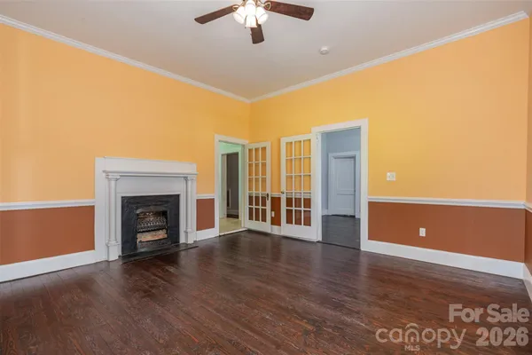 a view of a livingroom with wooden floor a fireplace and window