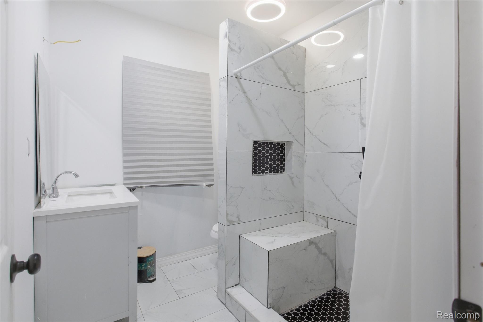 4624 Pacific Street Detroit, MI 48204 - Photo 17 of 39 Bathroom featuring vanity, a marble finish shower, and light marble finish flooring