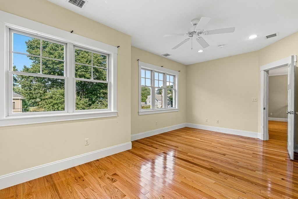 74 Oak Street Wellesley, MA 02482 - Photo 28 of 40 a view of an empty room with window chandelier fan and wooden floor