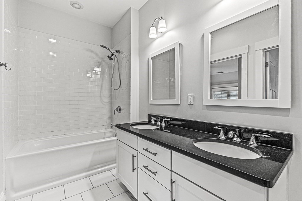 74 Oak Street Wellesley, MA 02482 - Photo 31 of 40 a bathroom with a granite countertop sink a mirror a and a bathtub