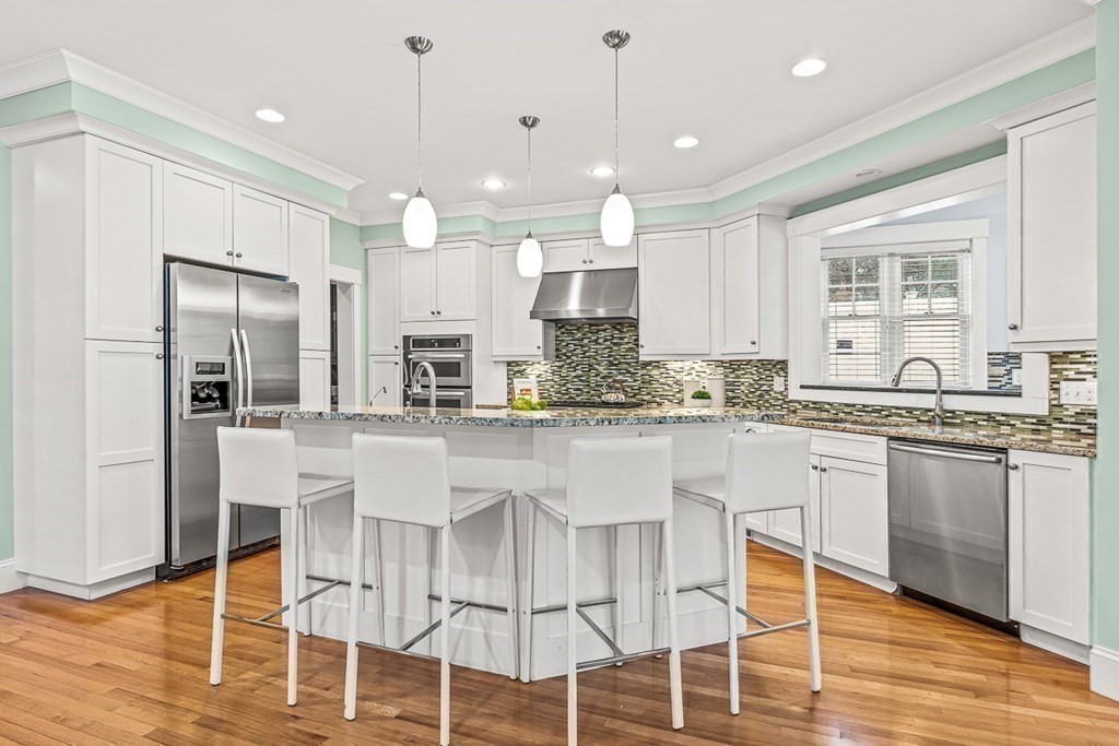 74 Oak Street Wellesley, MA 02482 - Photo 10 of 40 a kitchen with stainless steel appliances granite countertop a table chairs stove microwave and cabinets