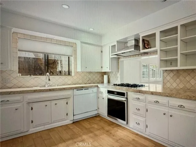 a kitchen with granite countertop cabinets stainless steel appliances and a sink