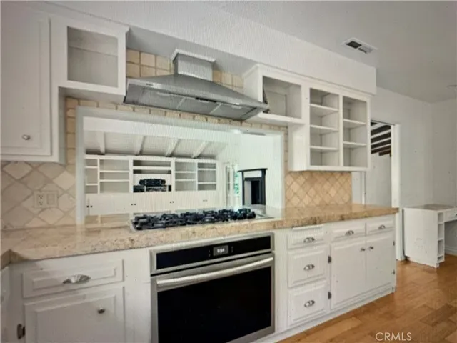 a kitchen with granite countertop a stove oven and cabinets