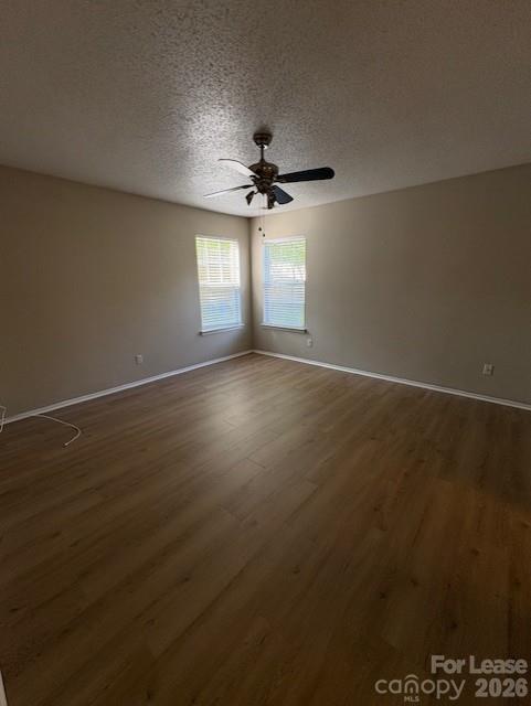3065 Parade Lane Southwest, Unit 121 Concord, NC 28025 - Photo 8 of 12 an empty room with wooden floor ceiling fan and windows
