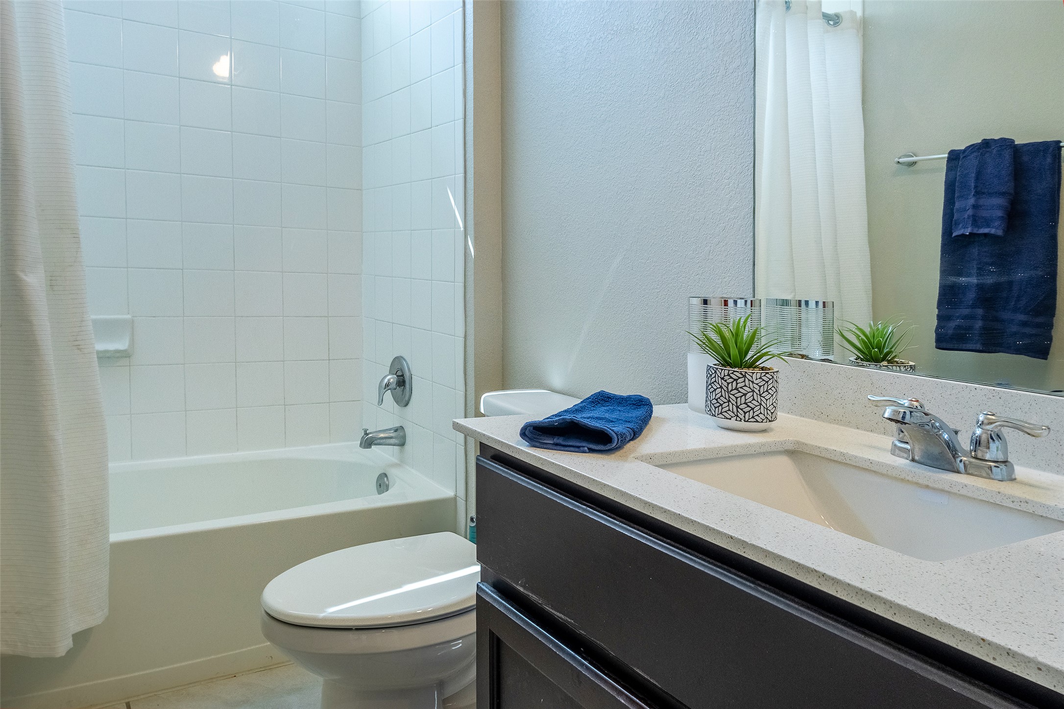 7225 Ranchito Drive Austin, TX 78744 - Photo 18 of 39 A well-appointed bath features a tiled tub and shower combination with a single vanity and mirror.