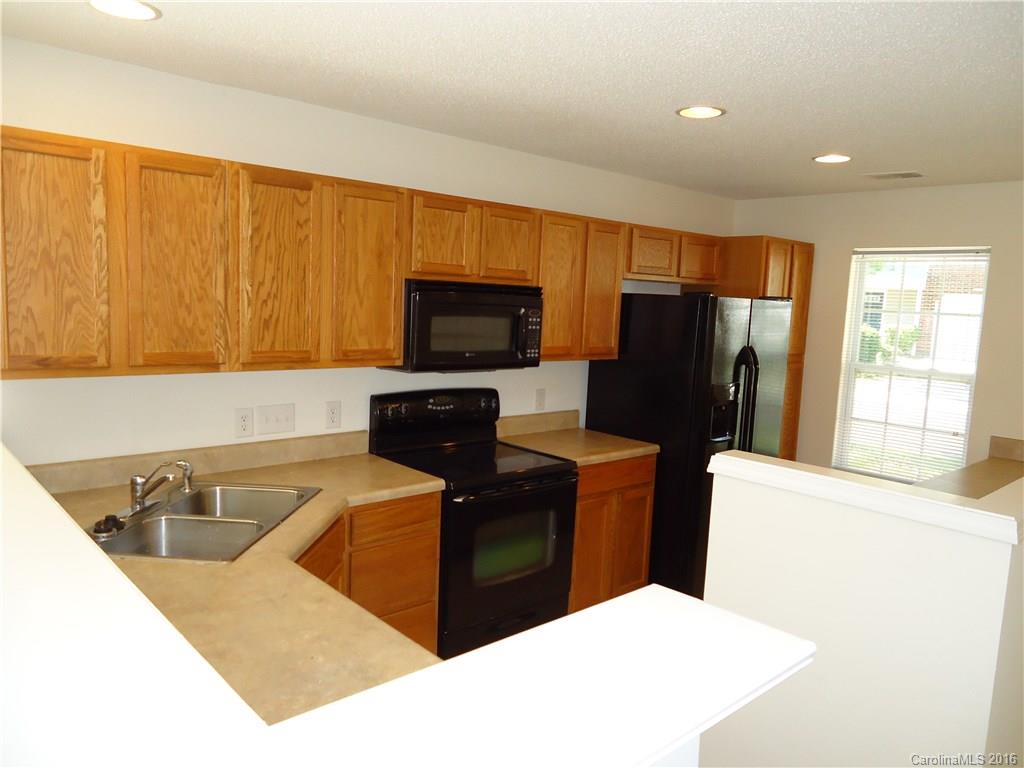 16824 Timber Crossing Road Charlotte, NC 28213 - Photo 3 of 23 a kitchen with stainless steel appliances a refrigerator a sink a stove top oven a refrigerator and cabinets