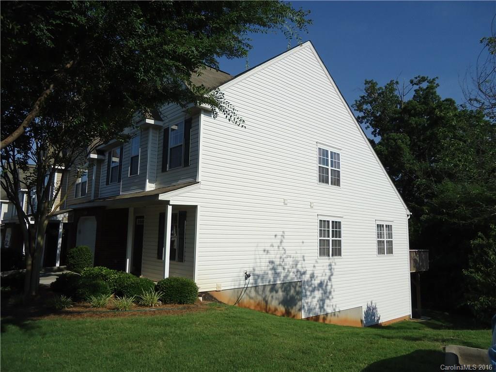 16824 Timber Crossing Road Charlotte, NC 28213 - Photo 22 of 23 a view of a white house in front of a yard with potted plants and large trees