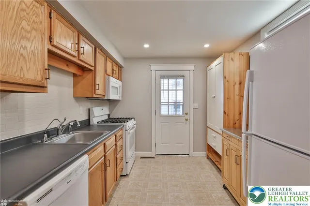 a kitchen with stainless steel appliances granite countertop a sink a stove and a refrigerator