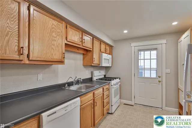 a kitchen with stainless steel appliances granite countertop white cabinets and window