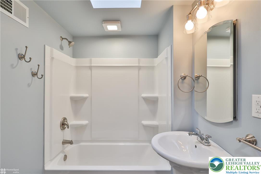 1035 Spring Street Bethlehem, PA 18018 - Photo 17 of 27 a bathroom with a bathtub a sink and a mirror