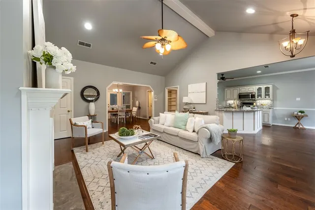 a living room with furniture a fireplace and a chandelier