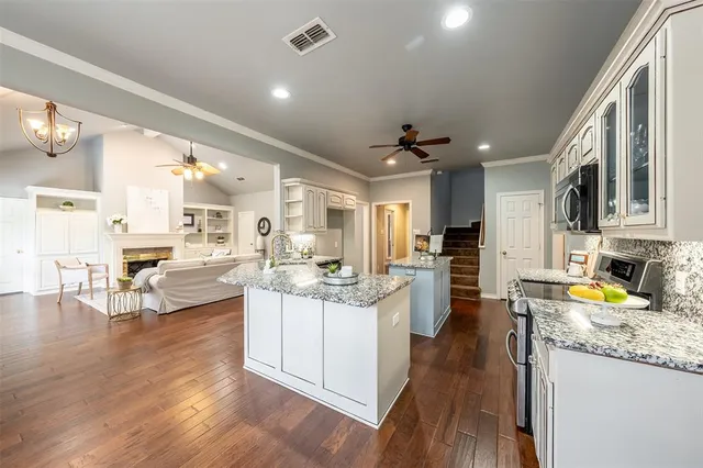 a kitchen with stainless steel appliances granite countertop a stove and cabinets