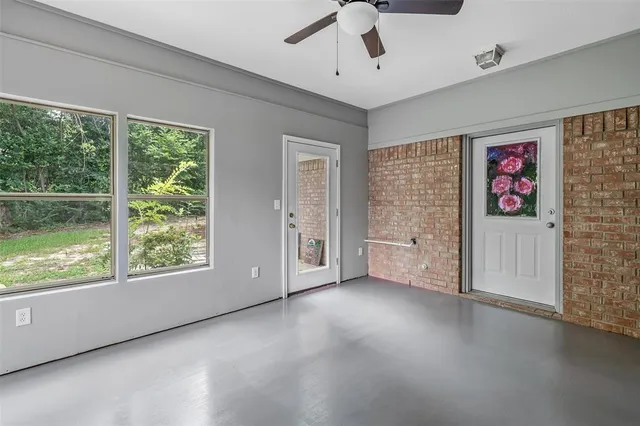 an empty room with fan and windows