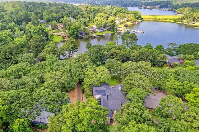an aerial view of a house with a yard lake and outdoor seating
