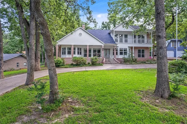 a front view of a house with a yard and an trees