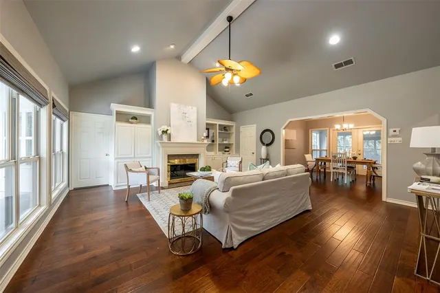 a living room with furniture a fireplace and a chandelier