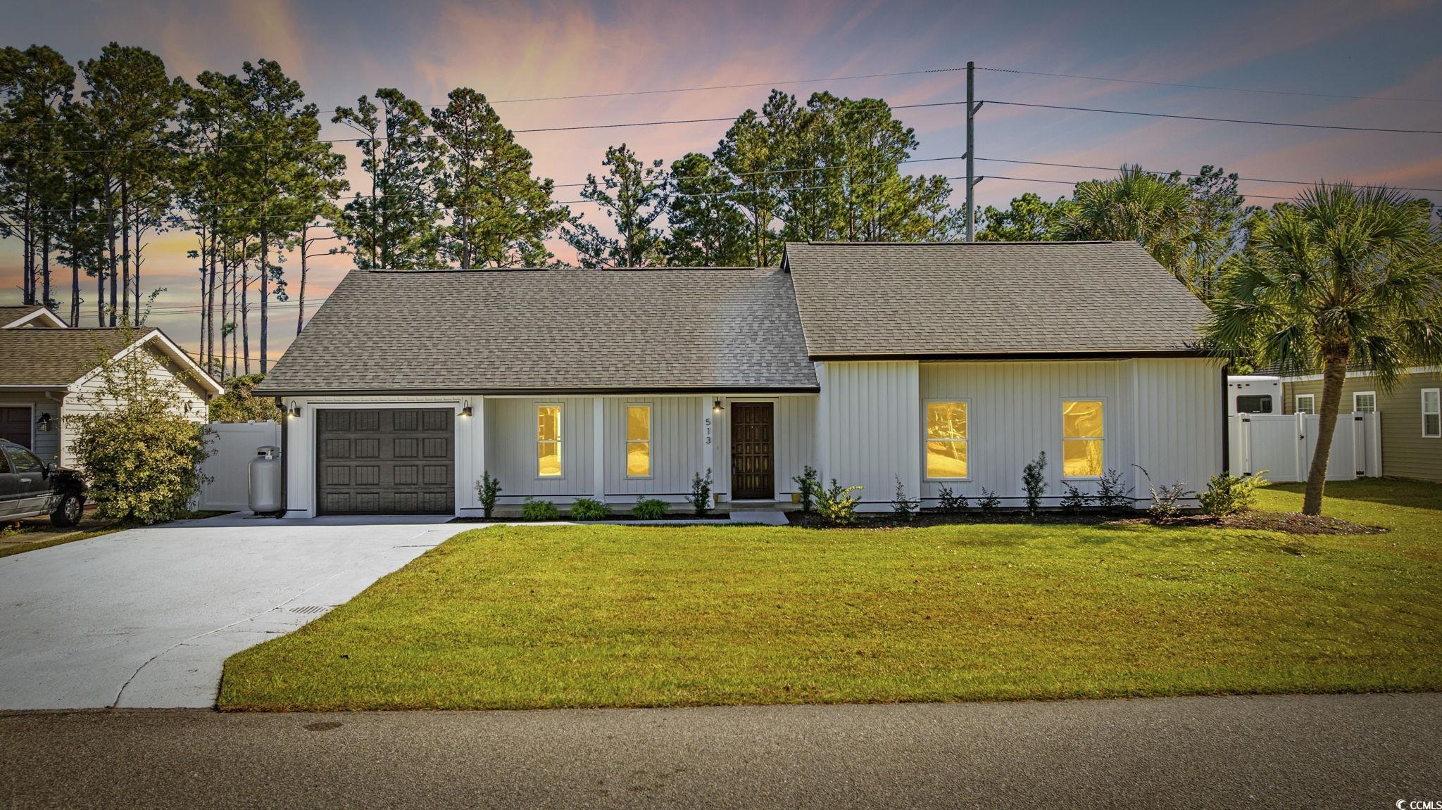 Mid-century home with roof with shingles, concrete driveway, and an attached garage
