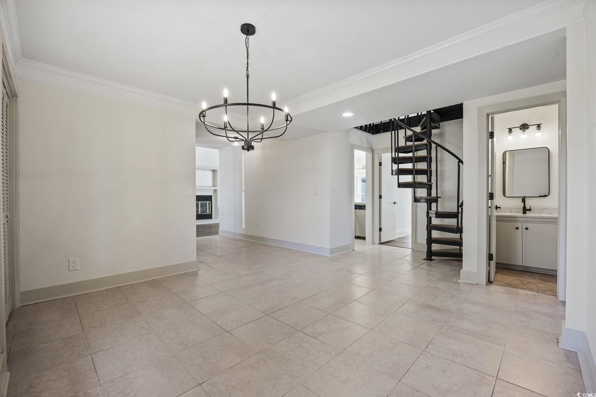 513 Plantation Drive Surfside Beach, SC 29575 - Photo 13 of 44 Dining room with ornamental molding, Spiral stairway leading to the bonus room and additional bedroom, a chandelier, light tile-patterned floors, and recessed lighting. Also, an entrance to a guest bathroom.