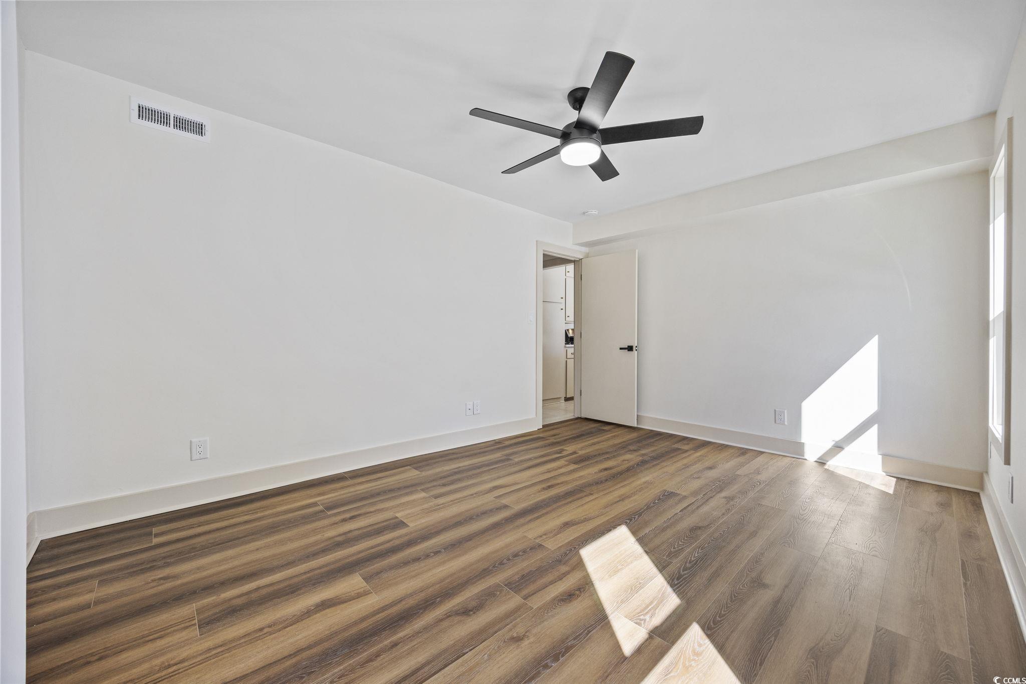513 Plantation Drive Surfside Beach, SC 29575 - Photo 16 of 44 Primary bedroom unfurnished, featuring a wood-finished floor look and a ceiling fan