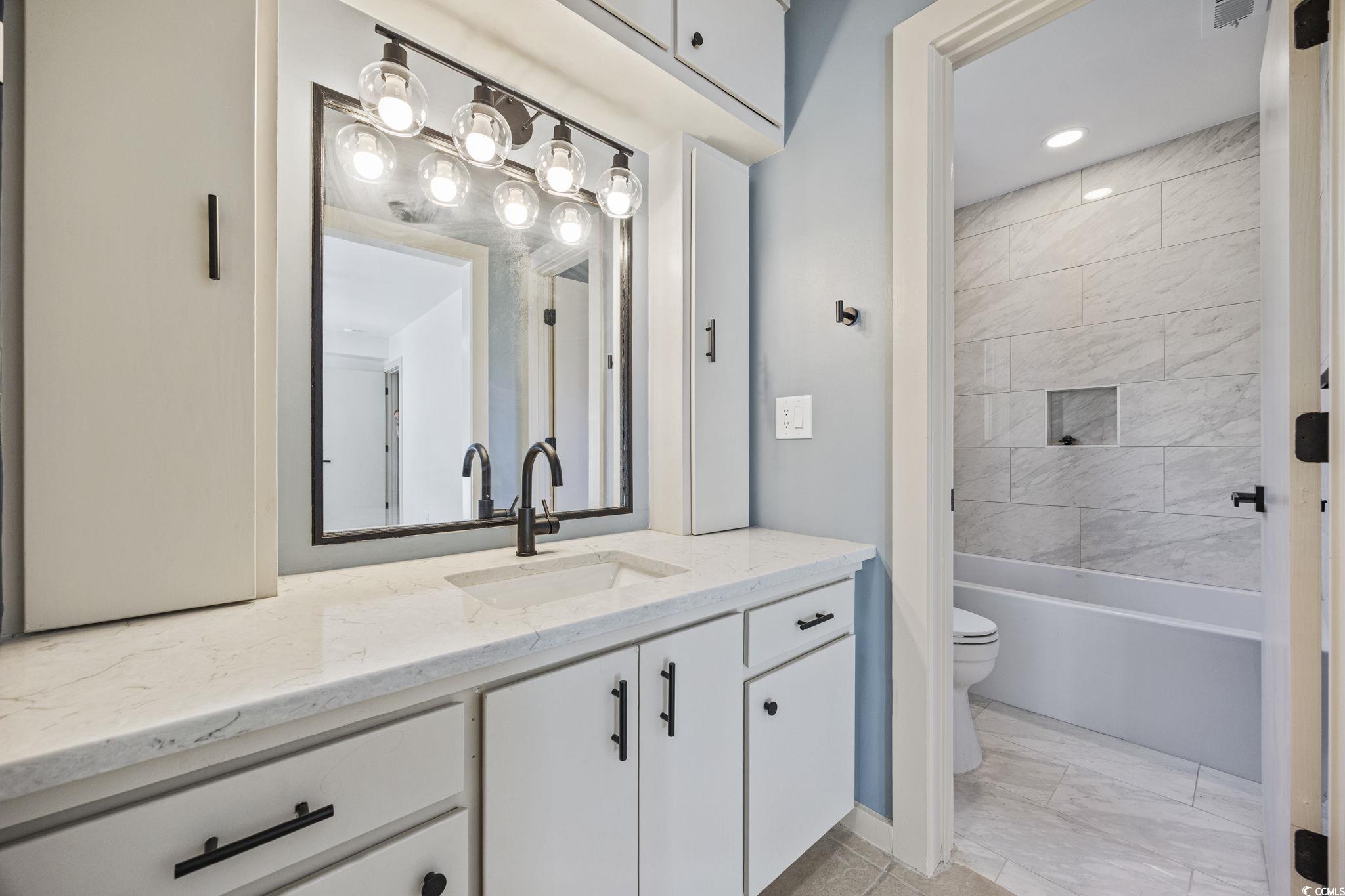 513 Plantation Drive Surfside Beach, SC 29575 - Photo 17 of 44 Full bath featuring vanity, washtub/shower combination, and light marble finish floors and shower/tub.