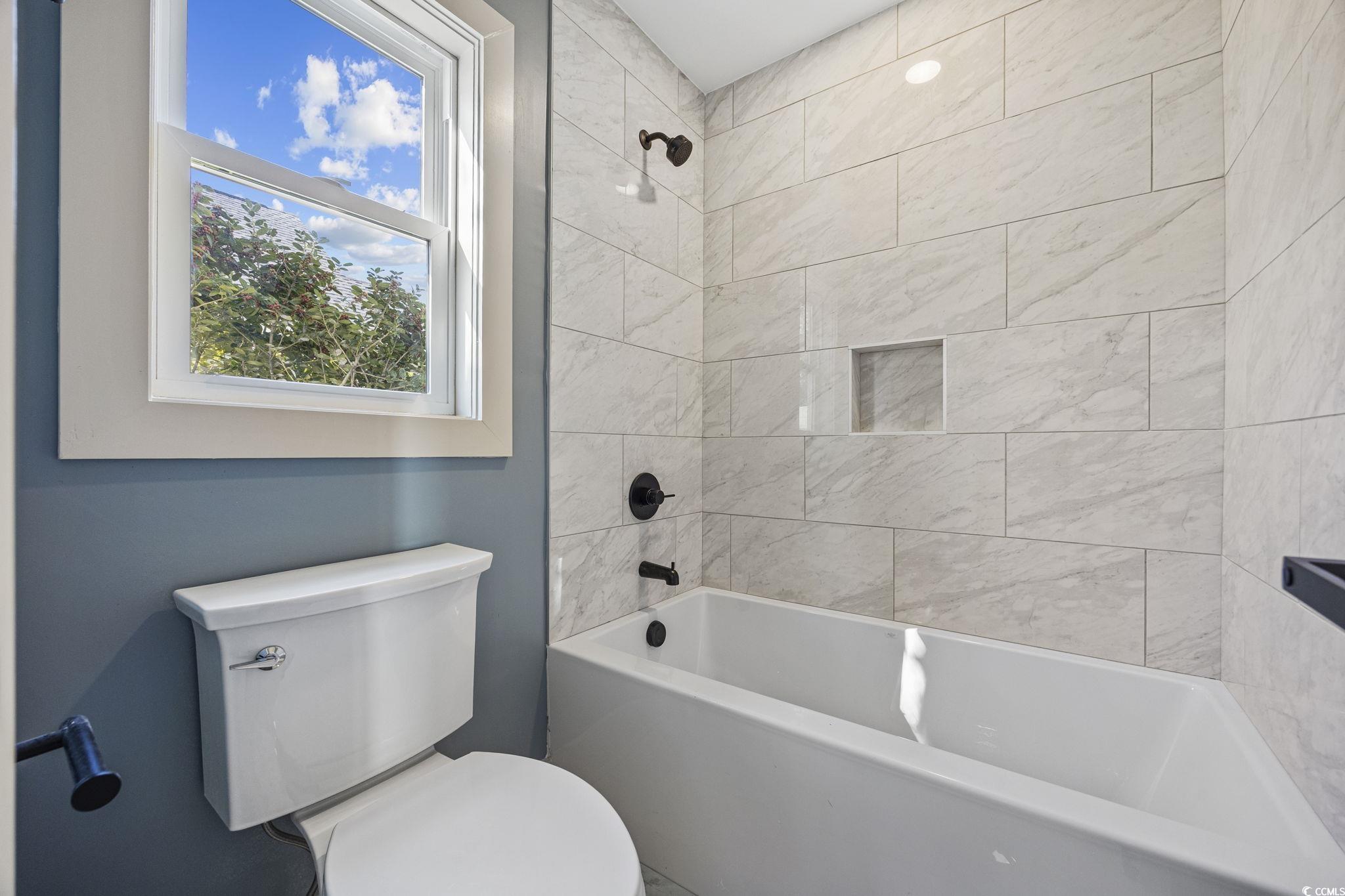 513 Plantation Drive Surfside Beach, SC 29575 - Photo 18 of 44 You will love this freshly updated full bathroom—complete with a stunning new tile surround, elegant black fixtures, and a stylish blend of modern comfort and timeless charm.