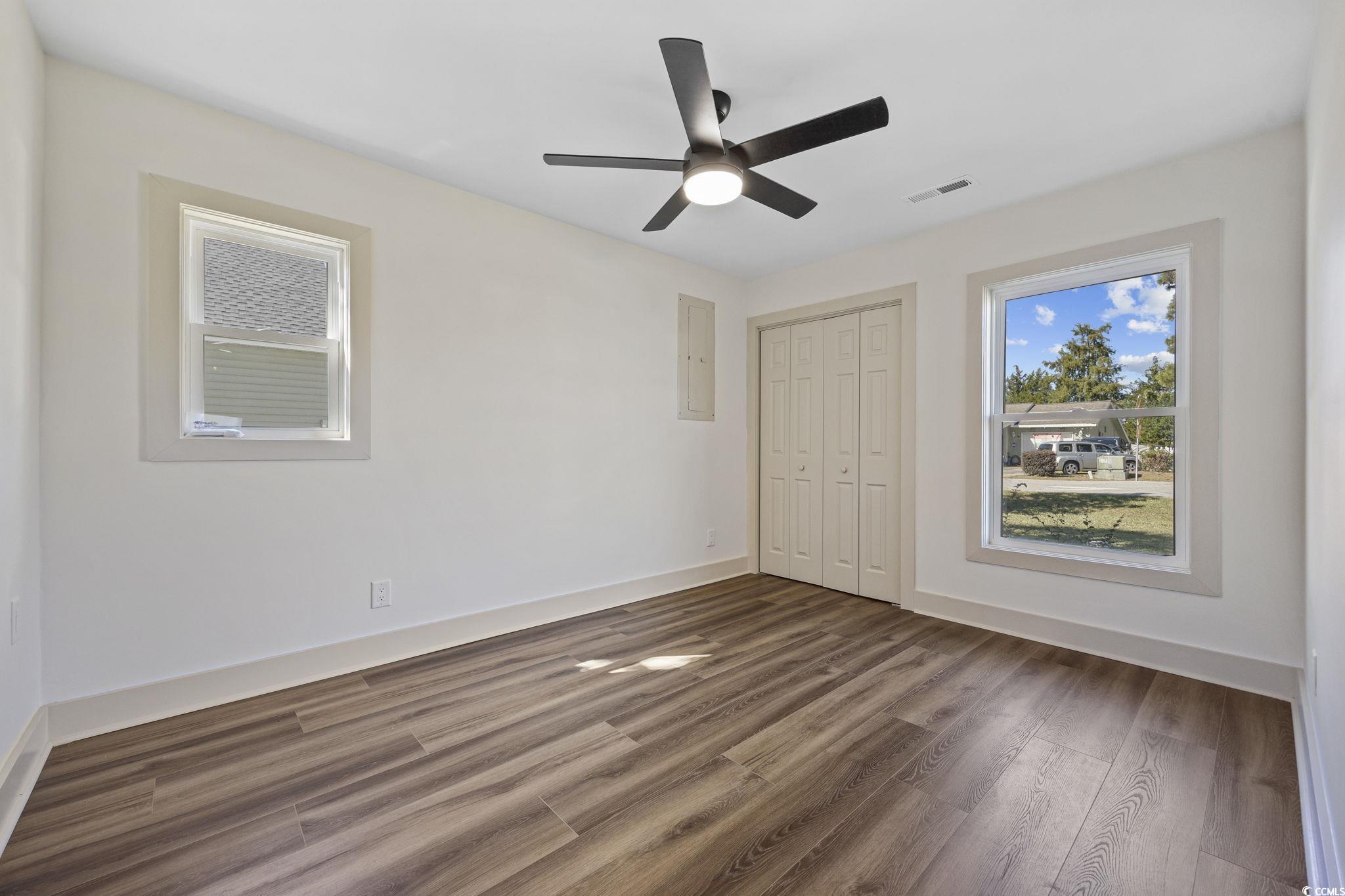 513 Plantation Drive Surfside Beach, SC 29575 - Photo 20 of 44 Downstairs, an unfurnished bedroom with wood-finished looking LVP floors, a ceiling fan, a closet, and an electric panel