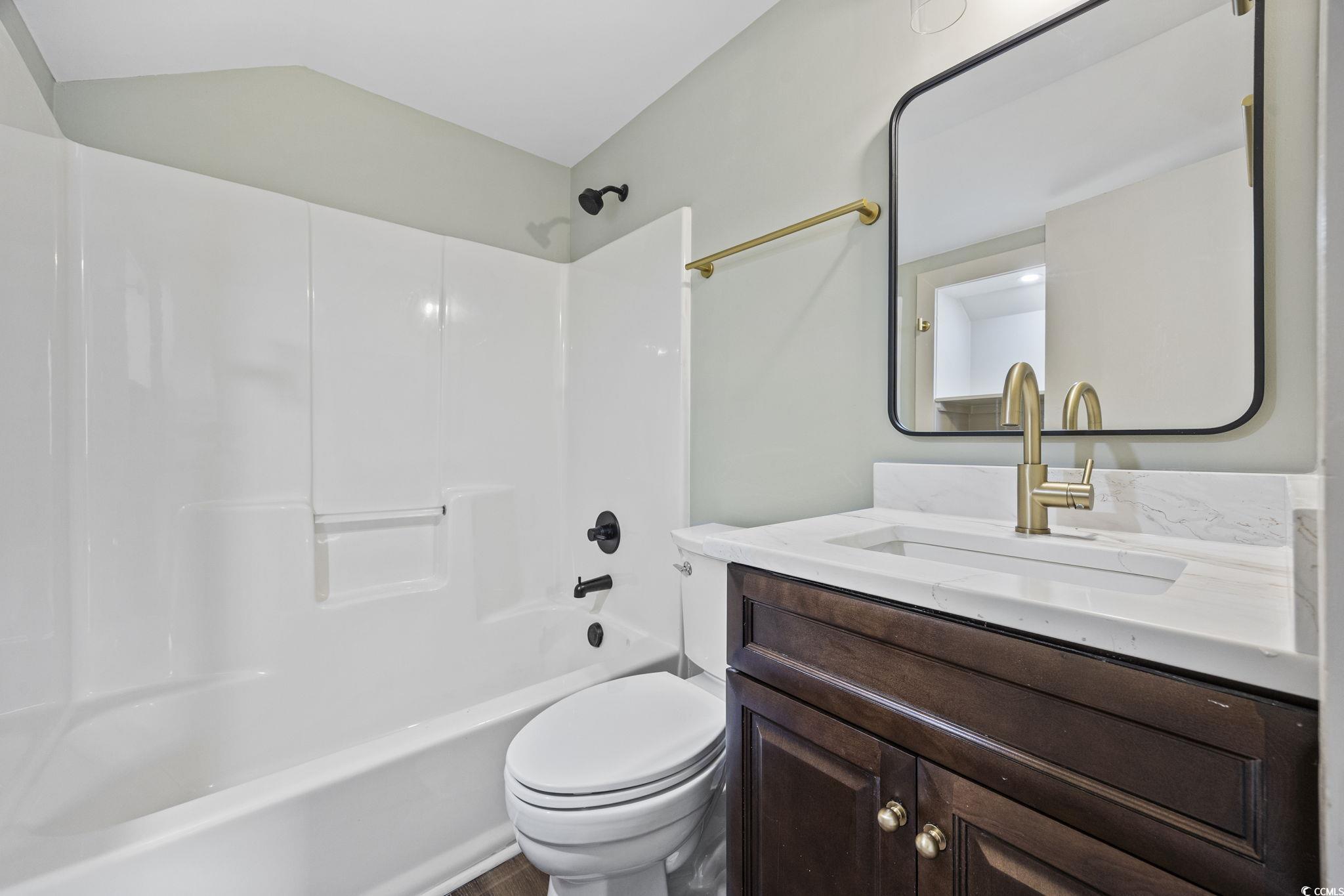 513 Plantation Drive Surfside Beach, SC 29575 - Photo 27 of 44 Fully remodeled ensuite bathroom featuring a stylish vanity and a relaxing tub and shower combination, completing the upstairs suite with comfort and modern design.