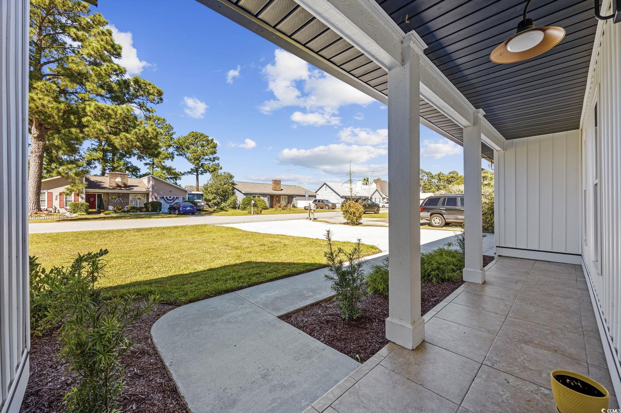513 Plantation Drive Surfside Beach, SC 29575 - Photo 33 of 44 Covered porch with a residential view and a lawn