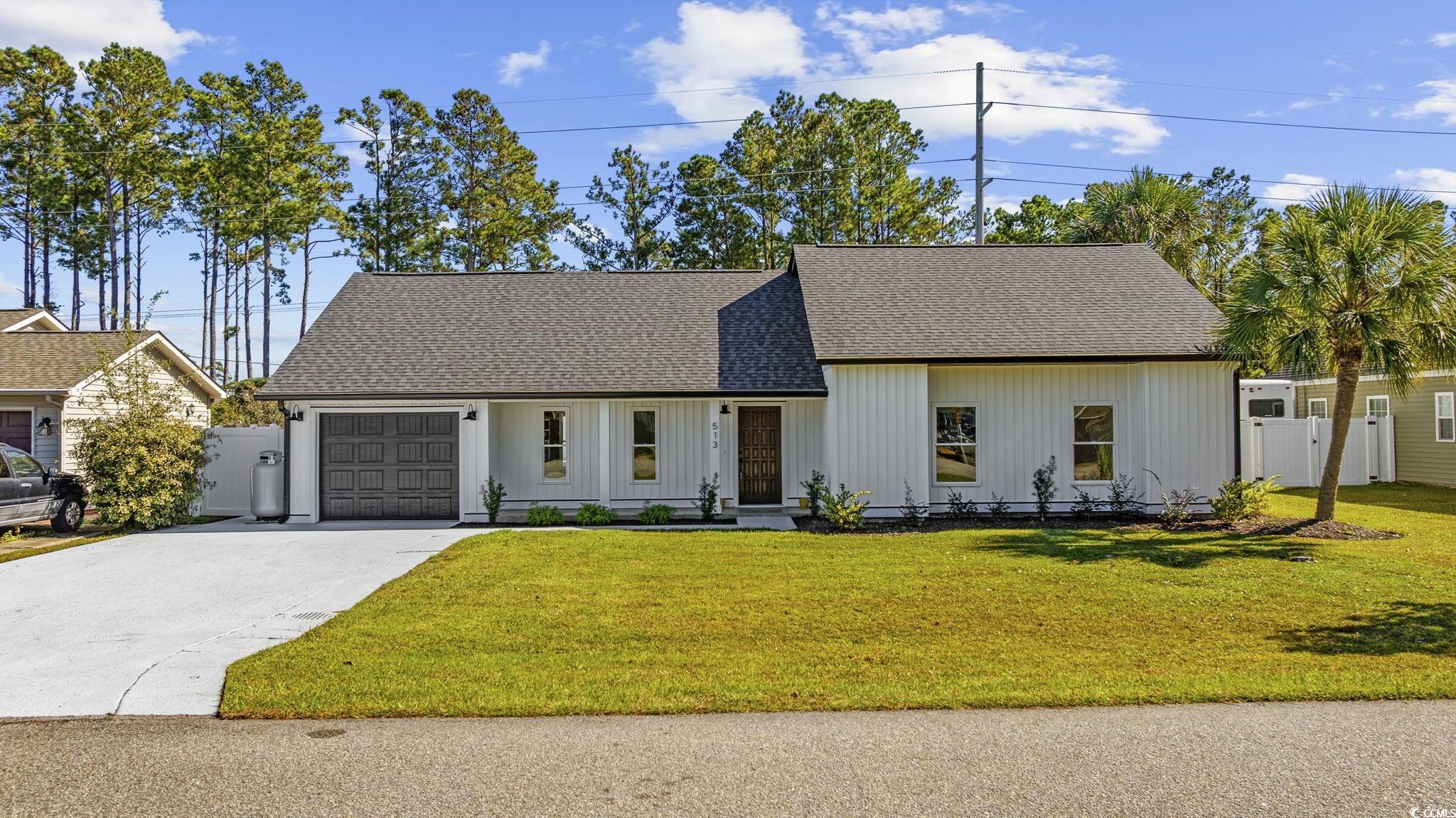 513 Plantation Drive Surfside Beach, SC 29575 - Photo 4 of 44 View of front of property featuring roof with shingles, concrete driveway, a porch, and an attached garage