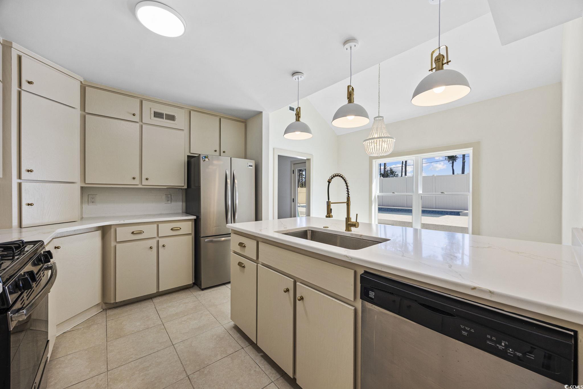 513 Plantation Drive Surfside Beach, SC 29575 - Photo 5 of 44 This thoughtfully designed kitchen exudes modern elegance, showcasing soft cream cabinetry, stunning quartz surfaces, and premium stainless steel finishes. Polished brass fixtures and statement lighting bring a designer touch.