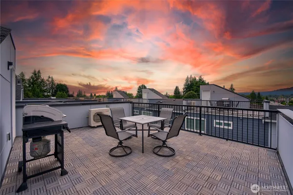 a view of a roof deck with table and chairs