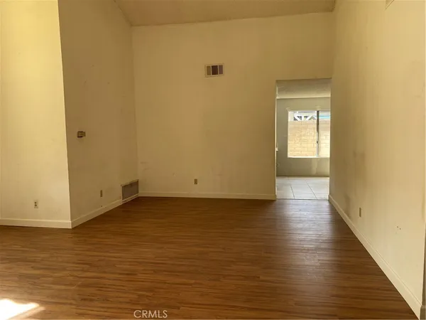 a view of a room with wooden floor and a window
