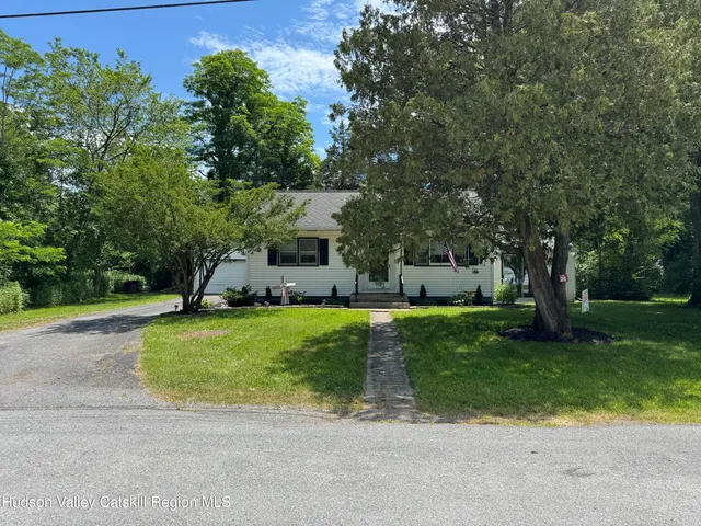 a front view of a house with a yard and trees